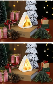 Detail of white triangle Christmas lanterns with warm LED trees and Santa silhouette