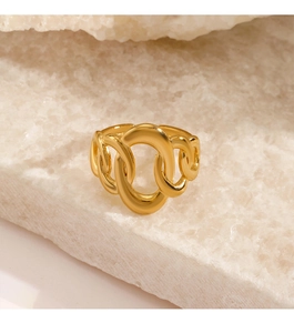 Macro shot of gold-plated chain link ring on a textured white mineral stone base