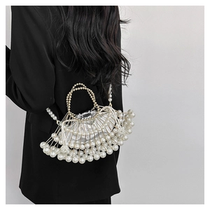 Detail of fan-shaped beaded handbag with metal frame and elegant pearl accents
