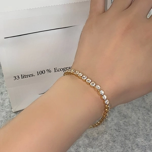 Close-up of a gold tennis bracelet with brilliant round zircons on a model wrist
