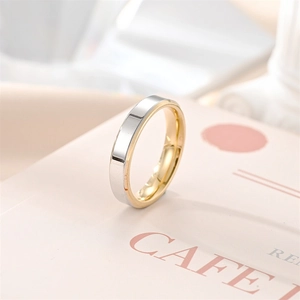 Detalle elegante de un anillo minimalista de acero de titanio bicolor en plata y oro.
