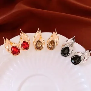 Three pairs of vintage teardrop crystal stud earrings in red, amber, and black gemstones