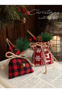 Close-up of linen Christmas gift bags with pine needles, berries, and bells decoration
