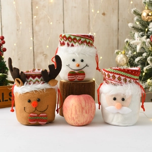 Detailed view of Santa, Snowman, and Reindeer felt Christmas gift bags on rustic wood