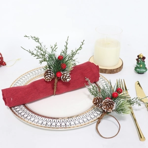 Rond de serviette de Noël avec aiguilles de pin, baies rouges et cônes sur table de fête