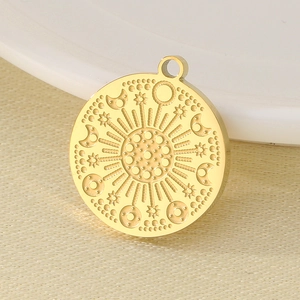 Close-up of golden stainless steel round pendant with sun and moon engravings