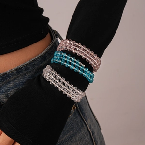 Close-up of layered beaded bracelet with pink, blue, and crystal glass beads over a sleeve