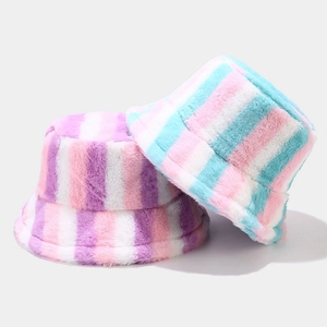 Detailed view of colorful striped plush faux fur bucket hats in pink and blue tones