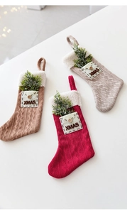 Detailed view of knitted Christmas stockings with plush cuffs and XMAS envelope pockets