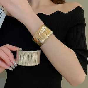 Polished gold and silver twisted cuff bracelets featuring vertical ribbed texture for women