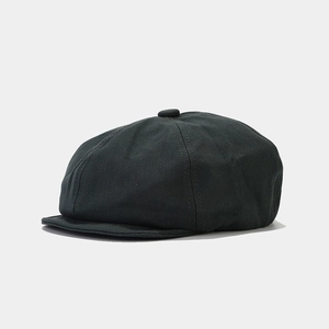 Detail view of the charcoal grey twill fabric and button top of this retro baker boy hat