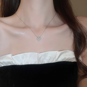 Close-up of a silver star pendant necklace with crystals worn on a female neck