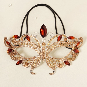 Detail view of butterfly masquerade mask with amber rhinestones and red marquise gems
