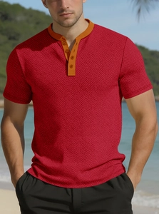 Détail du tricot à chevrons rouge avec col henley contrasté orange et boutons décoratifs