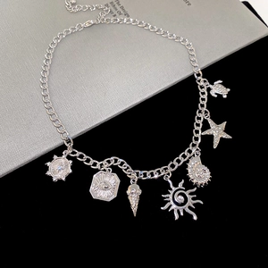 Macro view of silver star, conch and sea turtle charms on a delicate metal chain