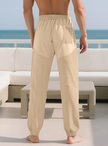 Detail view of khaki casual trousers with mesh panels and elastic waistband on a model