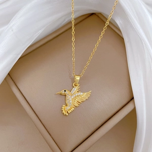 Luxurious gold hummingbird pendant necklace featuring sparkling white zircon stones