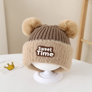 Dettaglio cappello in maglia per bambini con pompon in ecopelliccia e patch Sweet Time