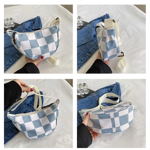 Detail view of blue and white checkered crescent waist bag with textured fabric surface