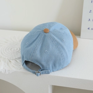 Kids denim baseball cap in light blue with brown contrast brim and adjustable metal buckle