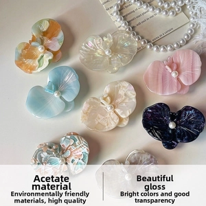 Detail of 8-piece acetate orchid hair clips set with glossy texture and pearl accents