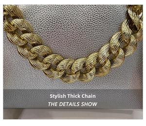 Detailed close-up of a gold chunky chain with intricate spiral textures and metallic finish