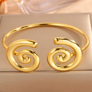 Polished gold open cuff bracelet with double helix spiral ends on jewelry box