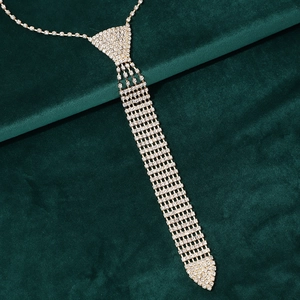Close-up of sparkling rhinestone tassel necklace with silver link chain on green velvet