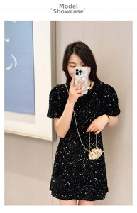 Close-up of a mini gold shell-shaped crossbody bag with a trendy metal chain strap