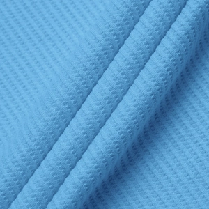 Macro shot of sky blue waffle knit fabric showing texture and softness of the polo shirt