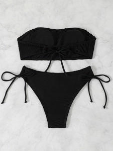 Detailed view of black bandeau bikini set with ribbed texture and adjustable side ties