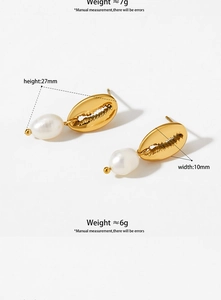 Detailed view of gold shell earrings with white drop pearls and a polished metallic finish
