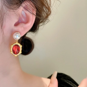 Macro detail of vintage resin earrings with faux pearls and gold textured oval frame