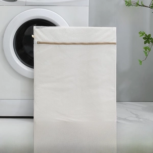 Close-up of small beige mesh laundry bag with rabbit print and zipper size 30X40CM