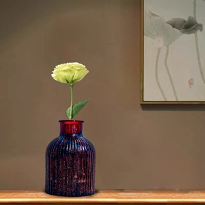 Close-up of a striped purple gradient resin vase with starburst texture on a wood table