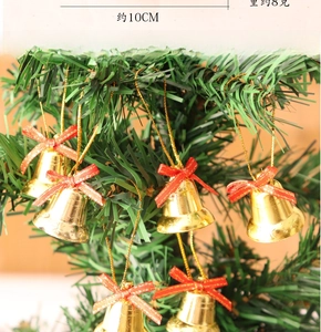 Detail of Christmas golden bells with red bows hanging on tree branches, 10cm size