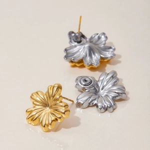 Macro view of bicolor flower earrings showing polished gold and silver metal textures