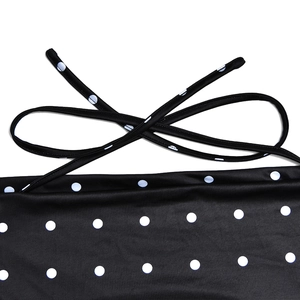 Detail of black polka dot backless dress featuring thin adjustable shoulder straps