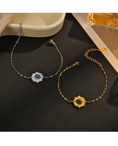 Detail of 14K gold and silver star moon bracelets with blue enamel sun pendant charms