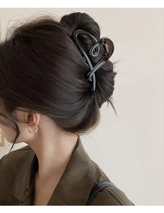 Vue détaillée d'une grande pince à cheveux marron foncé sur modèle montrant la taille