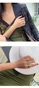 Close-up of stacked vintage gold rings and fresh water pearl bands on a woman's hand