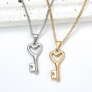 Detailed close-up of gold and silver heart-shaped key pendant necklaces on chain
