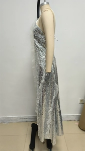 Close-up of silver sequin evening dress with delicate white mesh ruffles on the side
