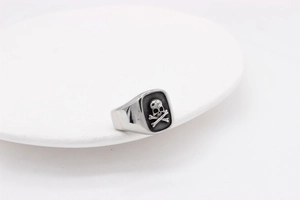 Macro shot of vintage skull and crossbones carving on polished titanium steel ring