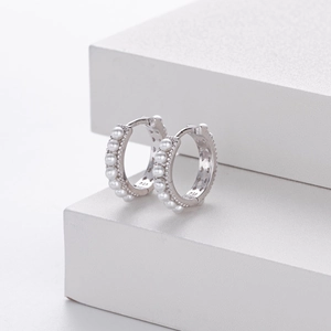 Detailed macro view of 925 sterling silver stamp and white pearls on the earrings