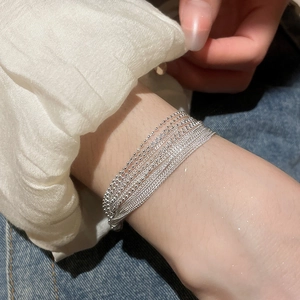 Detail of silver multi-layer beaded bracelet worn on wrist for a minimalist style