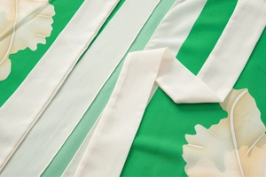 Detailed view of the tropical leaf print fabric and ruffles on a green swimsuit