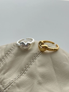 Close-up of S925 sterling silver heart rings with lava fluid texture in gold and silver