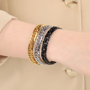 Close-up of polished stainless steel Cuban bracelets in gold, silver and black finishes