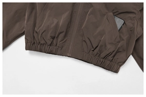 Close-up of the functional pocket and metal zipper on the brown outdoor sports jacket